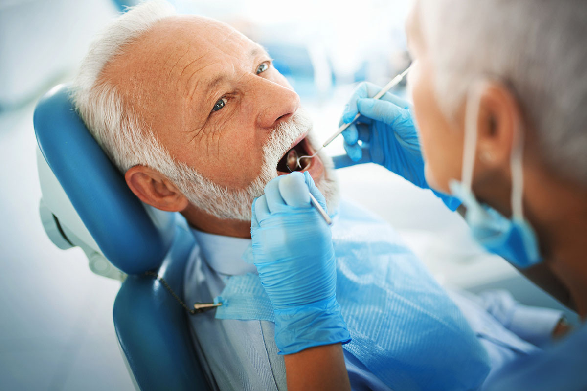 Man in chair getting checked by dentist